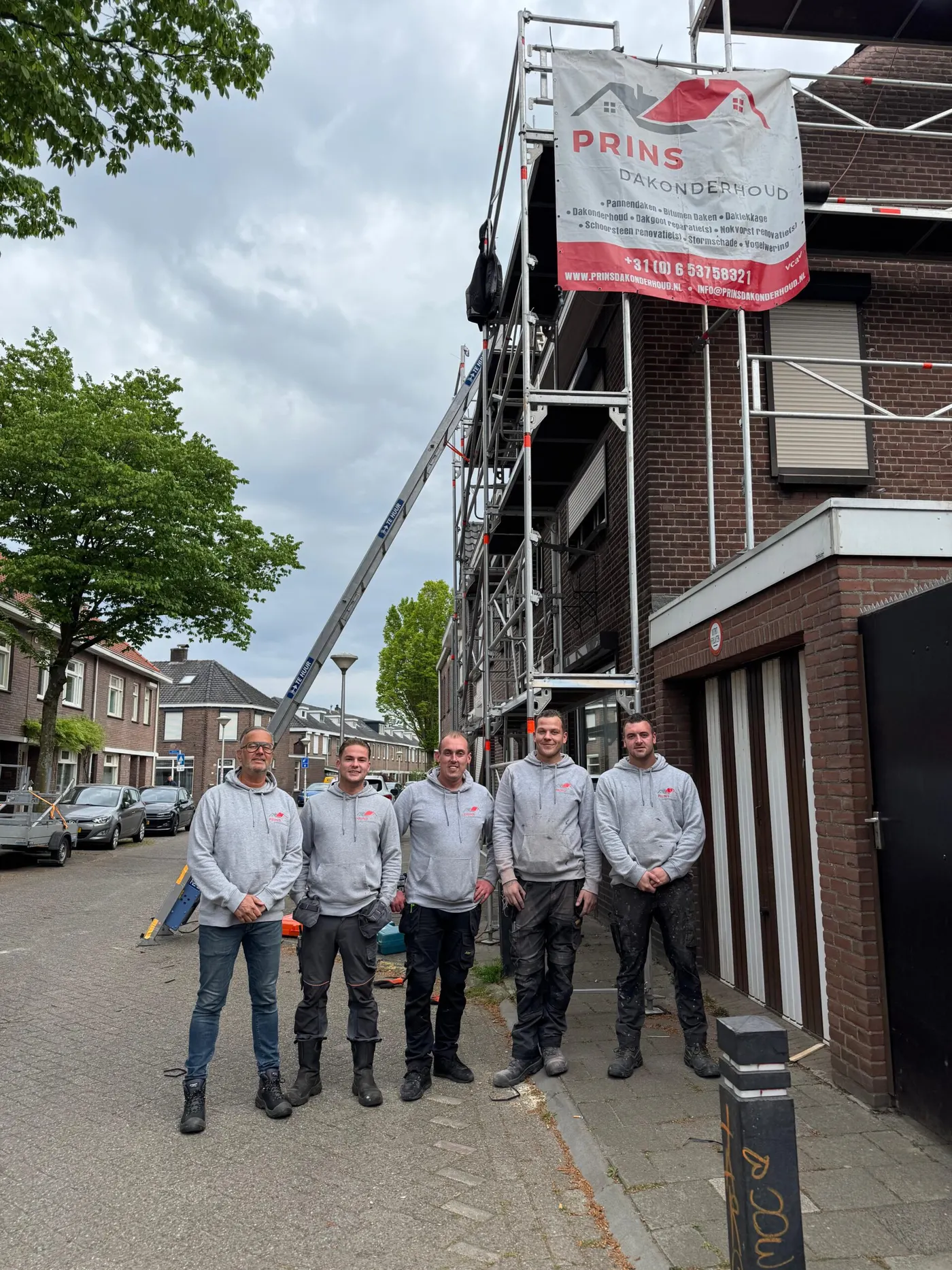 Maikel, Ramon, Sam, Kevin en Ian van Prins Dakonderhoud voor een steiger met het Prins-spandoek